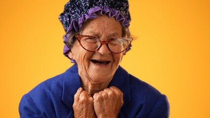 Closeup portrait of toothless elderly senior old woman with wrinkled skin having great happy...