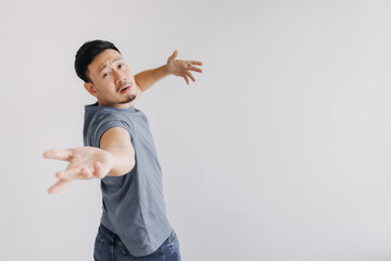 Funny and dramatic asian man is showing and offer hands stand isolated on white.