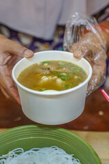 A chicken soup seller is serving customers