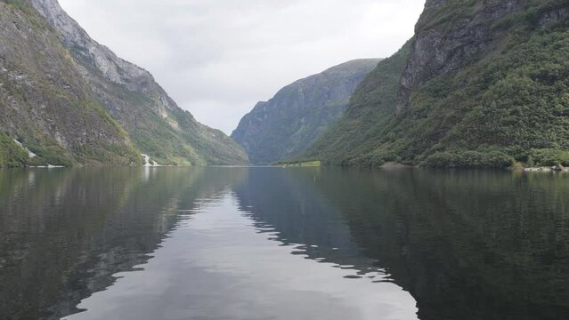Mirror lake reflecting the high mountains in fjords.