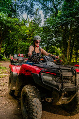 beautiful woman driving an ATV in the middle of the mountain on the shores of the Arenal volcano in Costa Rica