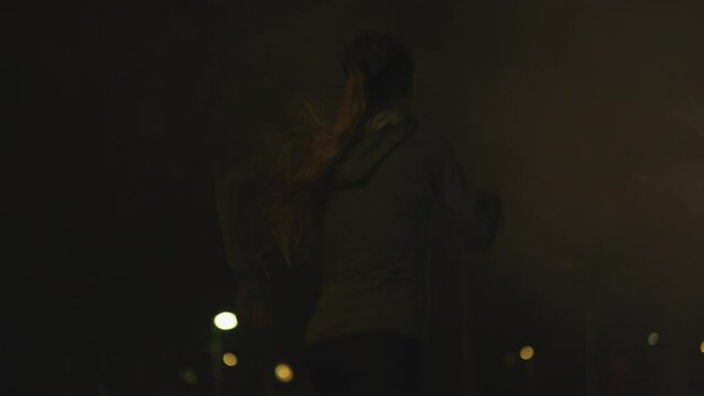 Back shot of a runner girl with mist and flashing
