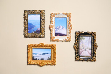 Vintage frames with photos of beautiful landscapes hanging on beige wall