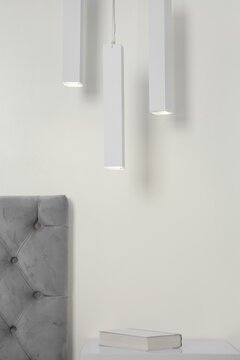 Stylish pendant lamps hanging over table in light room