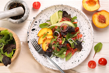 Delicious salad with vegetables and peach served on white wooden table, flat lay