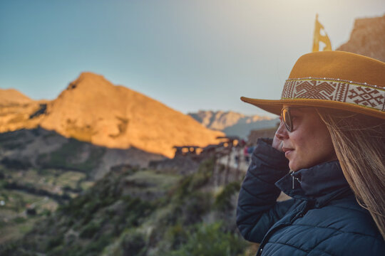 traveler hipster girl in hat with backpack exploring Pisac Archaeological of Peru.