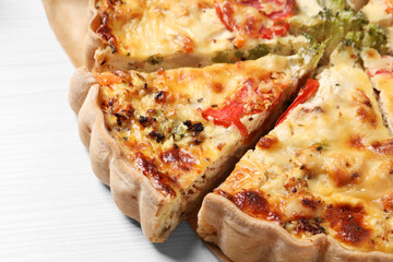 Tasty quiche with tomatoes and cheese on white wooden table, closeup