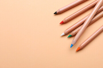 Colorful pastel pencils on beige background, space for text. Drawing supplies