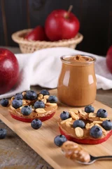 Fotobehang Slices of fresh apple with peanut butter and blueberries on wooden table, closeup © New Africa