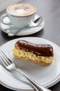 Chocolate eclair and cup of cappuccino