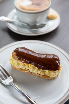 Chocolate eclair and cup of cappuccino