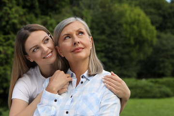 Naklejka premium Happy mature mother and her daughter in park
