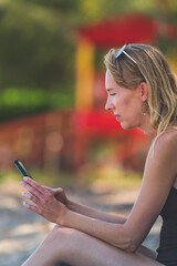 close up Woman using smartphone while vacationing on beach
