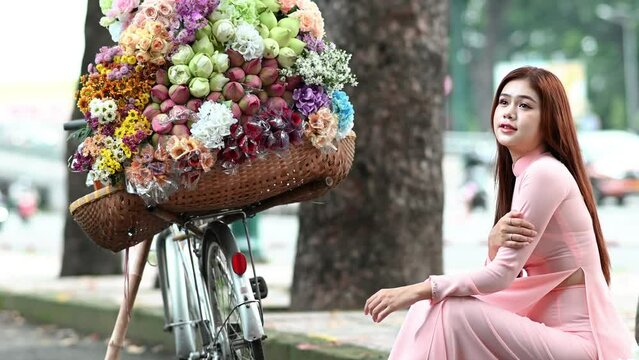 A young girl wearing a pastel pink ao dai, the traditional costume of Vietnam. Advertising video for tourism, culture, tradition, beauty of Asian