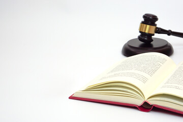 Close up  law book and blurred the judge gavel or hammer placed behind. Law, judiciary concept.