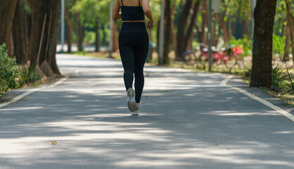 Young Asian woman wearing black exercise clothes Running for exercise in the park