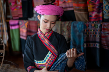 Pretty  Asian Tai Lue women beautifully wearing local dress traditional fabrics and textiles with unique craftsmanship and famous sarong at the old house at Chiang Mai, Thailand.