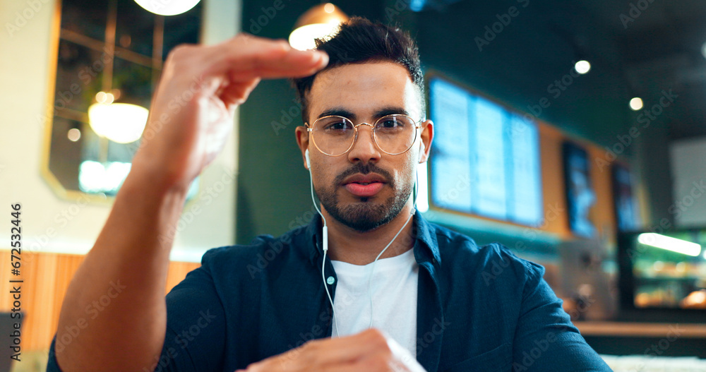 Poster Video call, portrait or man in cafe talking in mobile conversation as communication. Earphones, networking or entrepreneur in coffee shop or restaurant in discussion or speaking to explain online