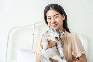 Beautiful asian woman smile and embrace the charming adorable cat, Adorable domestic pet concept.