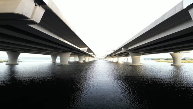 Symmetrical Underpass View of a Large Bridge Over Water, Vertical Shot
