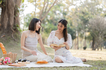 Two beautiful LGBT young women in casual clothes and summer hats Carefree woman having a picnic...