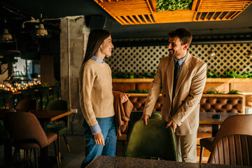 Man and woman in an animated conversation, exchanging thoughts about the upcoming meeting in a relaxed cafe atmosphere