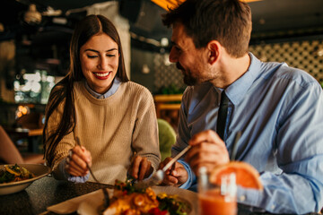 A diverse couple sharing a meal in a cozy cafe