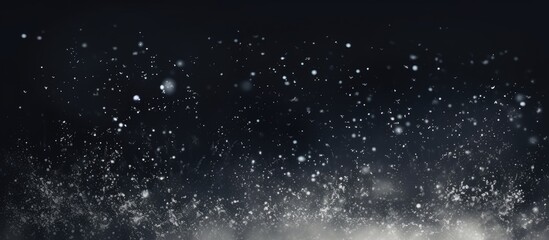The scene captures white snowflakes falling against a black background with a focus on the flying snowflakes and the soft bokeh effect Additionally there are dust particles or powder partic