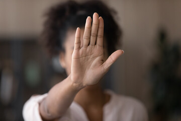 Young African American woman making hand stop denial gesture, saying no violence, abuse, abortion, showing palm, expressing prohibition, refusal, fighting against discrimination, bullying. Close up