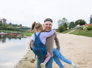 Fototapeta premium family dad and little daughters play on the beach