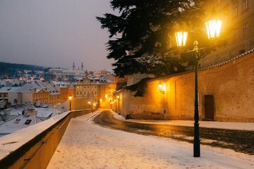 Fototapeta na wymiar Winter twilight in Prague, snow, no one, lights on, city center