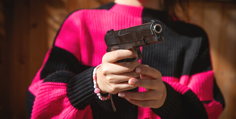 Caucasian young woman holding a pistol.