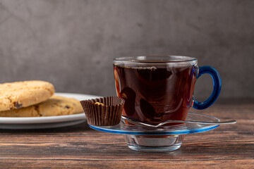 Traditional black turkish tea with lemon and cookies on wooden background