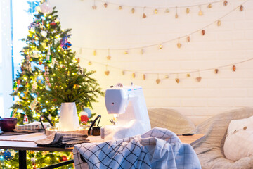 Sewing process on a sewing machine, a needle with a thread and a holder close-up stitch the white checkered fabric. Preparation for Christmas and new year, textiles for cozy in festive decor interior