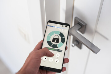 Man with mobile phone using smart home security system application