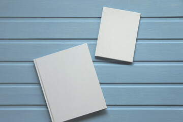 two books with an empty white cover on a wooden background. mockup album.