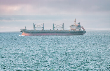 Landscape view of a large and heavy cargo container ship in the San Francisco Bay for the transport...