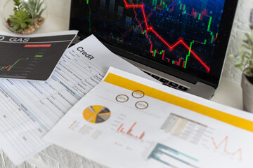 Bitcoin price is falling down and the entire crypto currency market is loosing money. The graph evolution of this coin on a laptop screen with red background. Strong sell signal