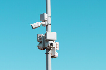 Street pole with CCTV cameras on blue background