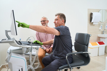 Experienced ultrasound technician consults patient in an ultrasound room