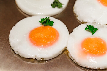 Eggs fried round shaped on metal surface, close-up, selective focus