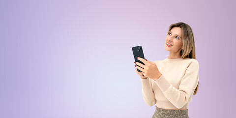 Cheerful young woman using smartphone, purple