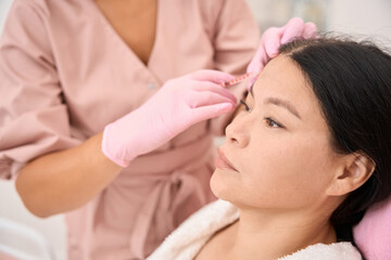Obraz na płótnie Canvas Woman receives beauty injections on her forehead