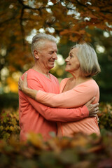 Elderly couple dance in the park in autumn.