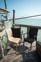 Scenic view of chairs outside a dock against sea