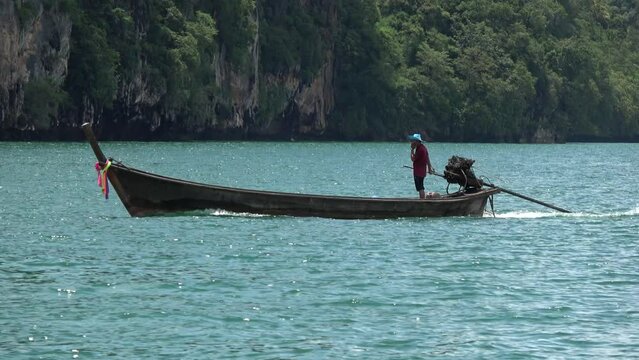 Low altitude aerial view of long-tail boat in Thai Ruea Hang Yao is type of watercraft native to Southeast Asia which uses common automotive engine as readily available and maintainable powerplant 4k