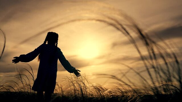 Happy family concept.child at sunset in field stretches out his arms and prays.baby outdoors in nature.image of happy baby at sunset.child praying with arms outstretched enjoying sunset. sunset prayer