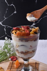 Fruitful Yogurt Medley: A delightful dessert ensemble featuring creamy yogurt paired with fresh fruits and crunchy muesli, served in a glass