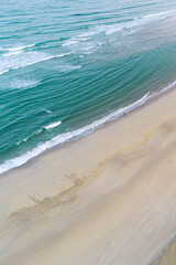 aerial drone view of the shore of a beach at morning in summertime