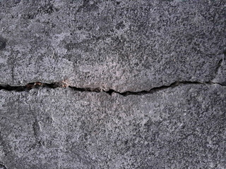 Grungy wall of gray concrete texture with cracked surface from sand and cement materials.